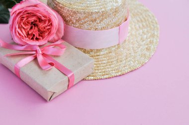 Yaz hasır şapka, pembe şakayık gül ve pembe arka planda yay ile hediye narin pejmürde kart. yakın çekim.
