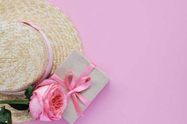 Yaz hasır şapka, pembe şakayık gül ve pembe arka planda yay ile hediye narin pejmürde kart. yakın çekim.
