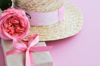 Yaz hasır şapka, pembe şakayık gül ve pembe arka planda yay ile hediye narin pejmürde kart. yakın çekim.