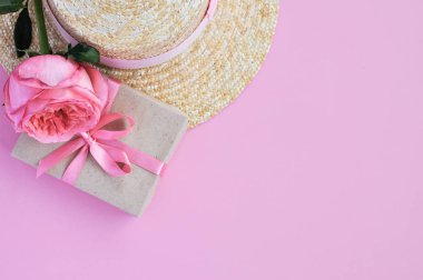 Yaz hasır şapka, pembe şakayık gül ve pembe arka planda yay ile hediye narin pejmürde kart. yakın çekim.
