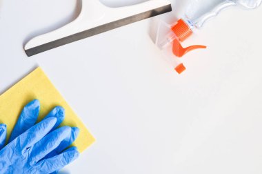 Evin genel temizliği. Pencereleri yıkamak için aksesuarlar: eldivenler, temizlik bezi, squeegee, sıvı deterjan.