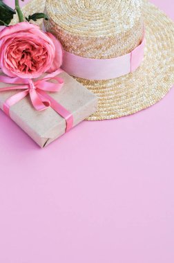 Yaz hasır şapka, pembe şakayık gül ve pembe arka planda yay ile hediye narin pejmürde kart. yakın çekim.