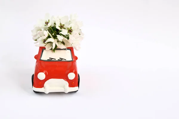 흰색 배경에 지붕에 꽃과 빨간 세라믹 자동차. 2월 14일 카드, 발렌타인 데이. 꽃 배달. — 스톡 사진