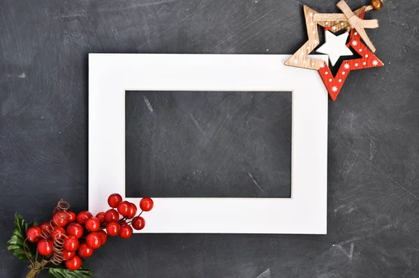 White text frame, a sprig of red berries Christmas Holly, Christmas decorations on a dark background.