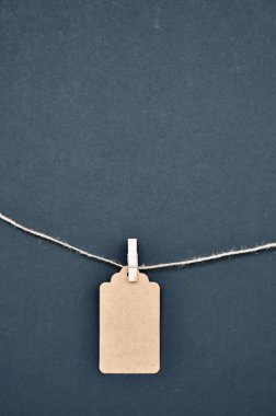 Kağıt zanaat indirim etiketleri siyah bir arka plan üzerinde halat clothespins ile eklenir.