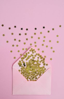 Tatil nazik kavramı: pembe zarf ve pembe arka plan üzerinde yıldız konfeti.