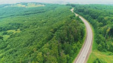 Geçen arabalar ile kavisli bir dolambaçlı yolun havadan görünümü. 4k.