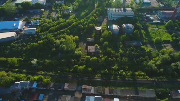 Luchtfoto van planten grondgebied, veel kamazes, trucks tussen groene vergulde bomen. 4k. — Stockvideo