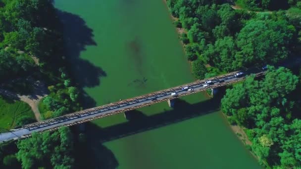 Εναέρια κορυφή κάτω όψη της κυκλοφοριακής εμπλοκής σε μια γέφυρα πάνω από ένα ποτάμι. 4K. — Αρχείο Βίντεο
