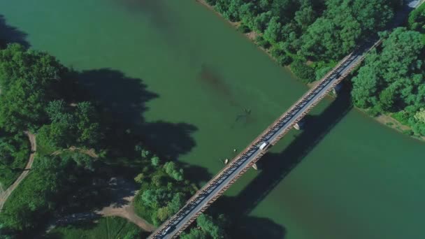 4k antenne Top Down View van auto's ontbrekende elkaar, rijden langs lange brug, over kalm groene water rivier. 4k. — Stockvideo