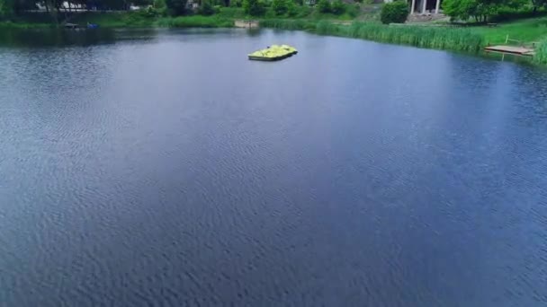 Přibližování a oddalování paddeleboats plovoucí na jezeře v malebném pozadí, který se nachází v zeleném parku. 4k. — Stock video