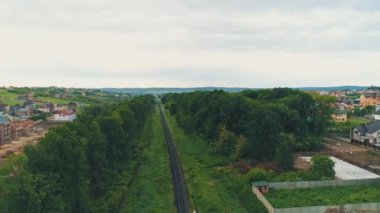Townstreet çatılar konut evler parklar banliyö seyahat yolu ve uzun demiryolu havadan havai görünümü.