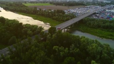 Ticari işletmelerin yakınındaki köprü boyunca hızlı hareket eden otoyol ve arabaların havadan çekilmiş görüntüleri. 4k.