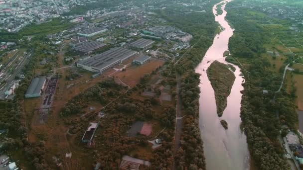 Vue aérienne d'un quartier résidentiel, où se trouvent beaucoup de maisons et de manoirs, une large rivière et le pont qui la surplombe. 4K . — Video