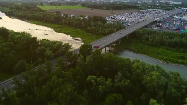 Antenn skott av motorväg och bilar, som rör sig snabbt längs bron nära kommersiella företag. 4K. — Stockvideo