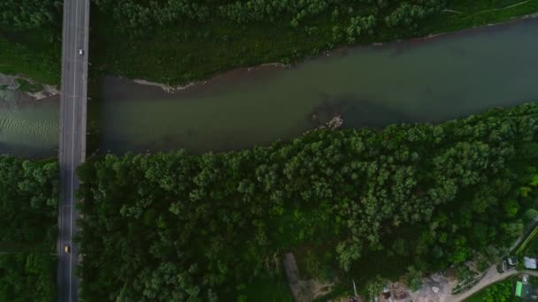 Vue aérienne de l'autoroute et des voitures, qui se déplacent rapidement le long du pont près des entreprises commerciales. 4K . — Video