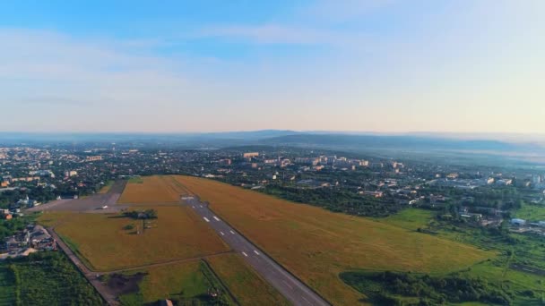 Vista aérea da pequena aviação, localizado em perto da cidade, com um edifício incrível e natureza. 4K . — Vídeo de Stock
