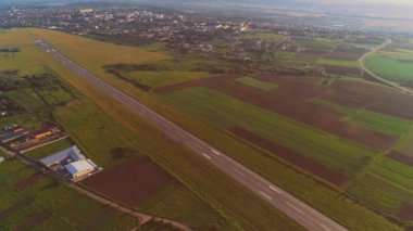 Kaçak ve beyaz uçak üzerinde uçan kalkış ile küçük havaalanının havadan görünümü. 4k.