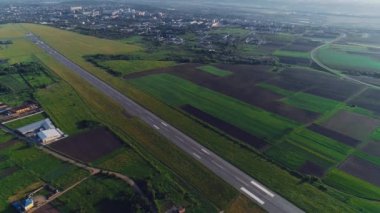 Kaçak ve beyaz uçak üzerinde uçan kalkış ile küçük havaalanının havadan görünümü. 4k.