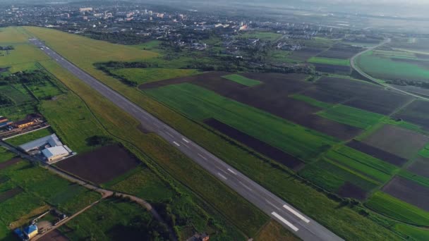 Flygbild av liten flygplats med take off skenande och vitt plan som flyger över. 4K. — Stockvideo
