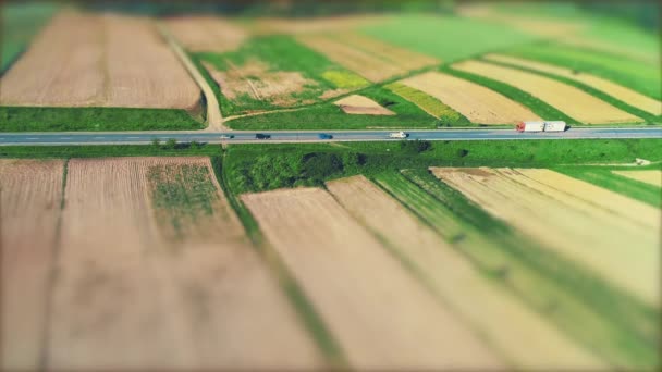 Vista aérea de los coches, moviéndose por la carretera de asfalto a través de un paisaje increíble con campos fructíferos. 4K . — Vídeos de Stock