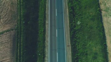 Yeşil çayırlar ve tarım alanları manzara ile boş çakıl yol boyunca sürüş farklı tip araçların havadan görünümü. 4k.