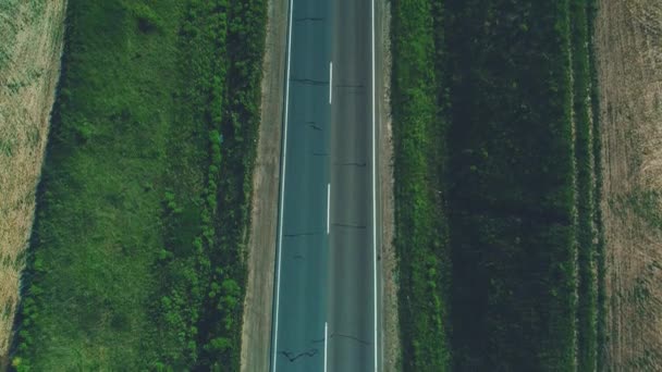 Aerial niewyraźne widok różnych samochodów typu jazdy wzdłuż pustej drogi żwirowej przez zielone łąki i pola rolne krajobrazu. 4K. — Wideo stockowe