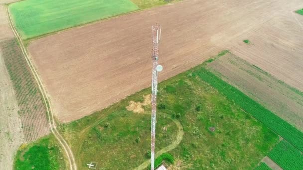 Cell phone telecommunication tower. Communication tower antenna is situated among plouged fields. 4K. — Stock Video