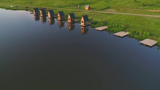 Top uitzicht op huisjes dicht bij vrij meer. Rust op het platteland in het zomerseizoen. 4k. — Stockvideo