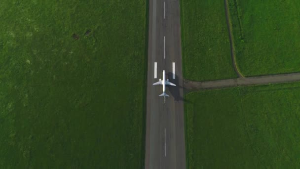 Widok z lotu ptaka gonić samolotu, który zabiera uciekający w środku zielonego trawnika. 4K. — Wideo stockowe