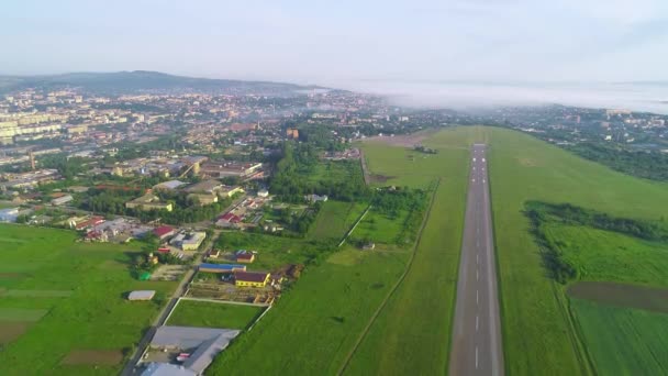 Vista aérea da pequena aviação, localizado em perto da cidade, com um edifício incrível e natureza. 4K . — Vídeo de Stock