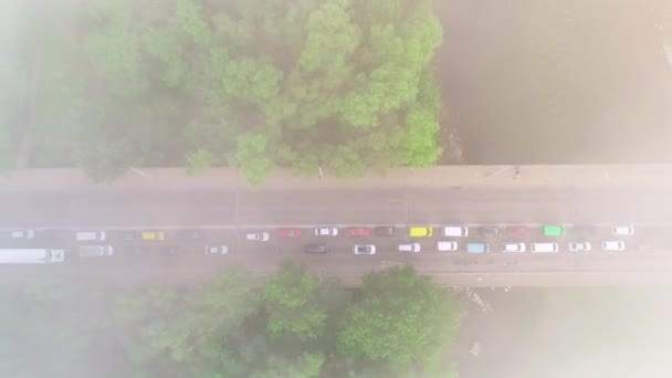 Vista aérea de la carretera forestal con coches, moviéndose a alta velocidad, luego el dron se mueve muy arriba en las nubes de niebla. 4K . — Vídeos de Stock