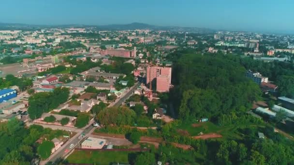 Luftaufnahme des Stadtlebens und zoomende Baustelle des neuen Wohnhauses Winde Turmdrehkran in der Nähe des großen Parkplatzes. 4k. — Stockvideo