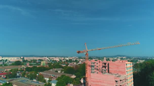 Luchtfoto van bouwplaats van nieuw woongebouw wint Torenkraan dicht bij grote parkeerplaats. 4k. — Stockvideo
