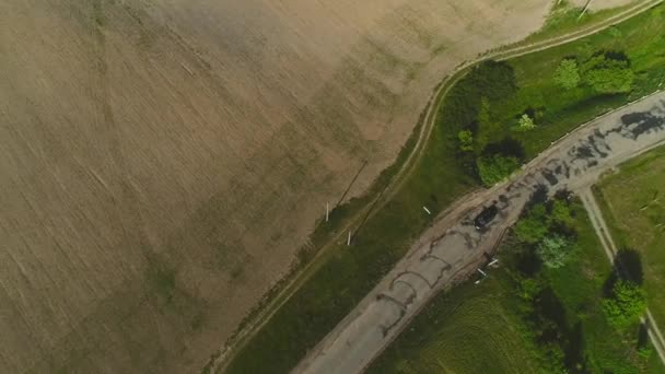 Vue aérienne suivante ci-dessus voiture conduisant à travers les terres agricoles. 4K .