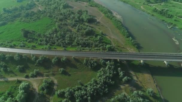 Sakin nehir üzerinde yalnız bir köprü yolunun havadan görünümü. 4k. — Stok video