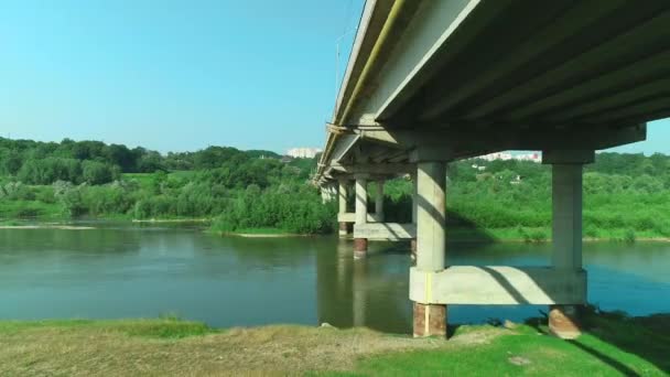 Воздушный полет под древним архедстоунным мостом через спокойную реку. 4K . — стоковое видео