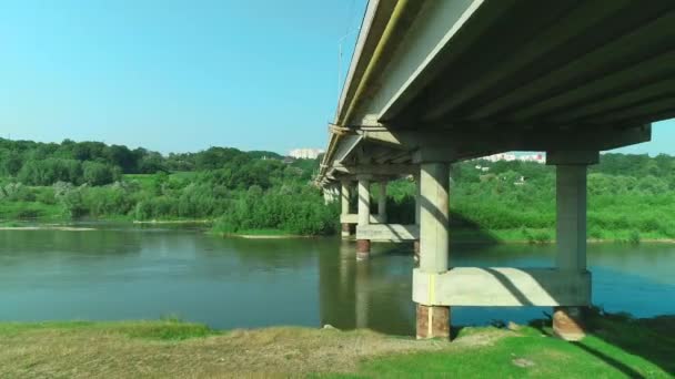 Vuelo aéreo bajo el antiguo puente de piedra arqueada sobre un río tranquilo. 4K . — Vídeo de stock