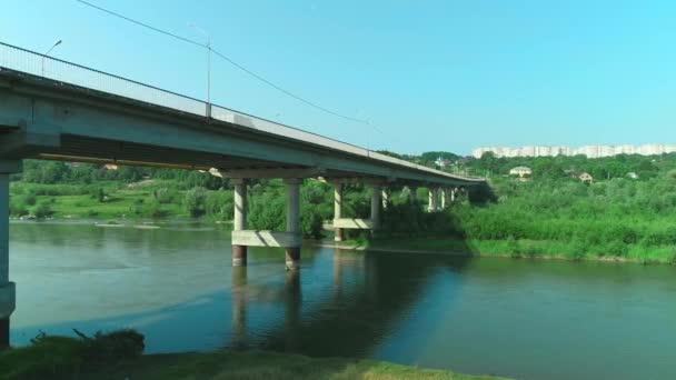 Luftaufnahme eines Autos, das die Hängebrücke über den ruhigen Fluss überquert. 4k. — Stockvideo