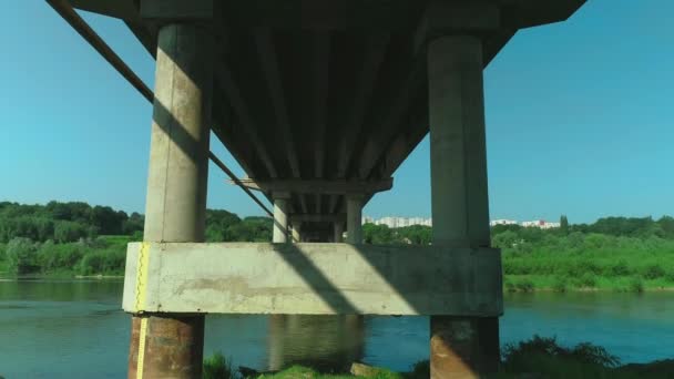 Vuelo aéreo bajo el antiguo puente de piedra arqueada sobre un río que se mueve rápido. 4K . — Vídeos de Stock