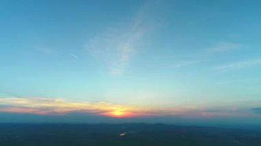 Zevk mavi gökyüzünde dramatik altın ışık gün batımı havadan 4k görünümü.
