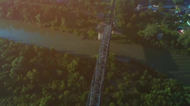 Rotating view of a train passsing by a railway bridge above the river. 4K — Stock Video