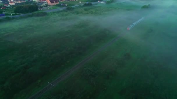 Luftaufnahme des Fernzuges, der bei Sonnenaufgang auf der Bahn unterwegs ist. 4k — Stockvideo