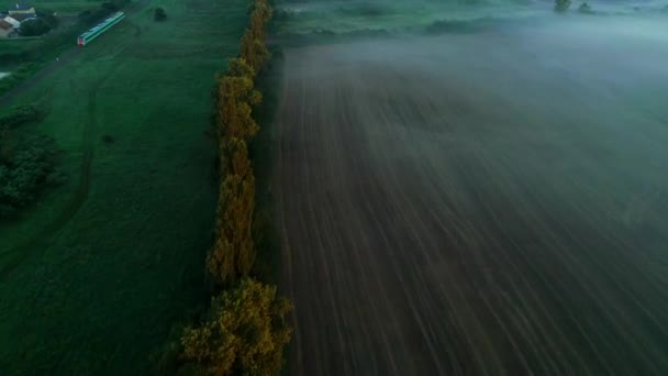 Dramatik sis ile banliyö bölgesinde tarım arazisi üzerinde havadan drone görüntüleri. 4k — Stok video