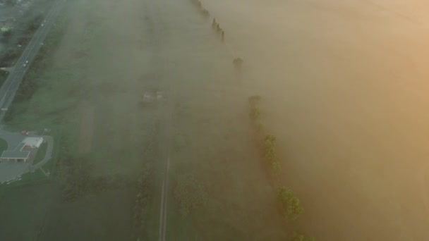 Yerleşim alanı yakınlarındaki sisli demiryolunun yüksek hava rotasyonu görüşü. 4k — Stok video