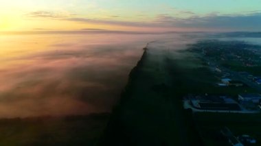 Şehir üzerinde sis veya sis ile gün batımı4k havadan görünümü.