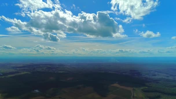 Αεροφωτογραφία πάνω από πράσινα πεδία, γαλάζιο ουρανό και σύννεφα. ευθείες γραμμές σε πεδία. — Αρχείο Βίντεο