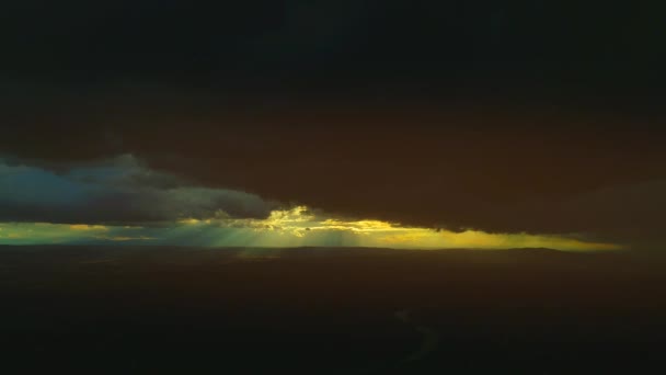 Nuvens e noite chuvosa tempestuosa com raios de sol. Feixes de luz solar disparam através de nuvens de tempestade e iluminam o chão. 4K — Vídeo de Stock