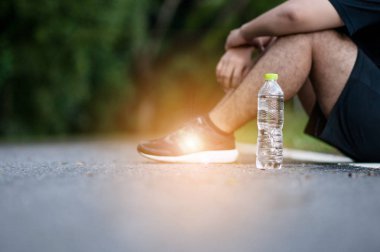 Genç yorgun adam yürüyüş açık havada yaz saati sonra bir dinlenme sahip. Sağlıklı yaşam konsepti