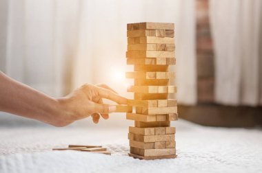 Modern ofisteki kuleye el çekmek ya da tahta bloğu yerleştirmek. Plan ve iş stratejisi. Arkaplan için bulanık.
